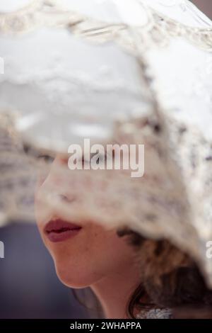 Les yeux de la femme regardent à travers le parapluie en dentelle à la verticale de la renaissance Banque D'Images