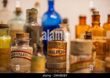 Vieilles bouteilles de médicaments derrière les anciennes bouteilles de vitrine avec d'anciennes écritures brunes dans la ville inca de Cuzco sur les hautes terres péruviennes Banque D'Images