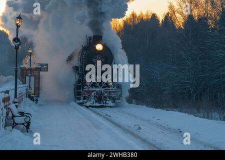Khelyulya, RUSSIE - 20 JANVIER 2024 : le train rétro 'Ruskeala Express' arrive à la gare de Moroznaya un matin de janvier. Carélie Banque D'Images