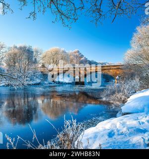 Une vue en hiver de la rivière North Tyne dans le Northumberland regardant à travers le pont Bellingham dans le village Bellingham avec ciel bleu et gelée Banque D'Images