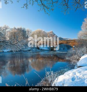 Une vue en hiver de la rivière North Tyne dans le Northumberland regardant à travers le pont Bellingham dans le village Bellingham avec ciel bleu et gelée Banque D'Images