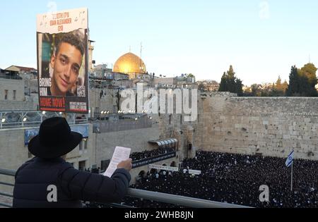 Une femme juive religieuse prie et tient une affiche avec une photo d'Edan Alexander, du 51e bataillon de la Brigade Golani qui est retenu en otage à Gaza, alors que les Juifs ultra-orthodoxes se rassemblent pour un rassemblement de prière spécial dans le mur Occidental, plaidant pour le salut d'Israël, la libération des otages, et la sécurité des soldats, au milieu du conflit dans le nord et le sud du pays le 8 février 2024 à Jérusalem Israël Banque D'Images