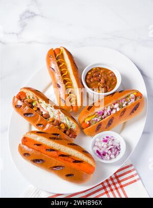Vue en grand angle de hot-dogs à base de plantes fabriqués à partir de carottes avec différentes garnitures ; espace de copie Banque D'Images