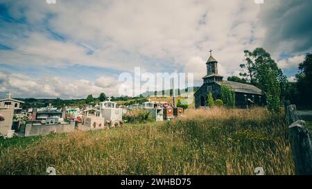 Vieille église en bois Nercon avec un vieux cimetière sur Chiloé avec une seule tour d'église et des colonnes blanches dans la zone d'entrée. Banque D'Images