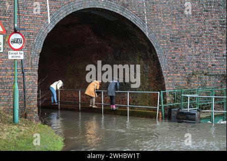 Major's Green, Bromsgrove, 9 février 2024. Trois femmes se sont retrouvées bloquées alors qu'elles essayaient de naviguer dans les inondations dans les Midlands. Les femmes ont finalement trouvé leur chemin hors d'une banque sur Peterbrook Road dans Major's Green et le long de balustrades métalliques comme de nombreux conducteurs passaient, provoquant d'énormes vagues d'arc en raison de fortes précipitations la nuit et tout au long de la journée. Crédit : arrêtez Press Media/Alamy Live News Banque D'Images