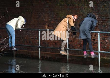 Major's Green, Bromsgrove, 9 février 2024. Trois femmes se sont retrouvées bloquées alors qu'elles essayaient de naviguer dans les inondations dans les Midlands. Les femmes ont finalement trouvé leur chemin hors d'une banque sur Peterbrook Road dans Major's Green et le long de balustrades métalliques comme de nombreux conducteurs passaient, provoquant d'énormes vagues d'arc en raison de fortes précipitations la nuit et tout au long de la journée. Crédit : arrêtez Press Media/Alamy Live News Banque D'Images