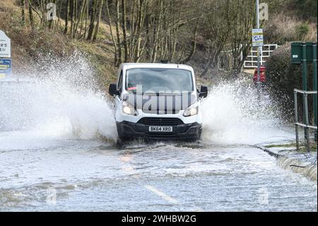 Major's Green, Bromsgrove, 9 février 2024. Trois femmes se sont retrouvées bloquées alors qu'elles essayaient de naviguer dans les inondations dans les Midlands. Les femmes ont finalement trouvé leur chemin hors d'une banque sur Peterbrook Road dans Major's Green et le long de balustrades métalliques comme de nombreux conducteurs passaient, provoquant d'énormes vagues d'arc en raison de fortes précipitations la nuit et tout au long de la journée. Crédit : arrêtez Press Media/Alamy Live News Banque D'Images