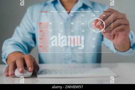 Homme d'affaires marquant les dates sur le calendrier virtuel, gérer son horaire d'affaires, définir des rappels pour les rendez-vous importants, collage créatif pour le plan Banque D'Images