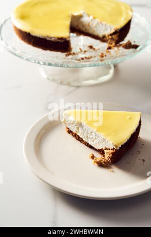 Cheesecake au mascarpone avec caillé de citron et base de sablé. Fond de marbre blanc. Photo de nourriture haute touche Banque D'Images