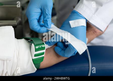 Une personne en gants mettant Une aiguille sur Un mannequin. Banque D'Images