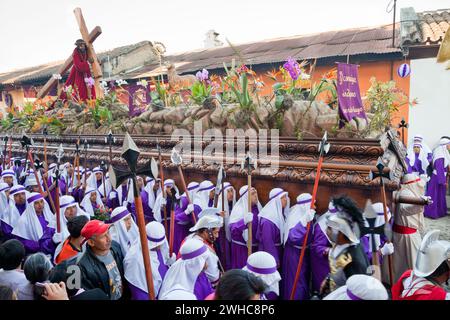 Antigua, Guatemala. Cucuruchos portant un char (Anda) dans une procession religieuse pendant la semaine Sainte, la Semana Santa. Banque D'Images