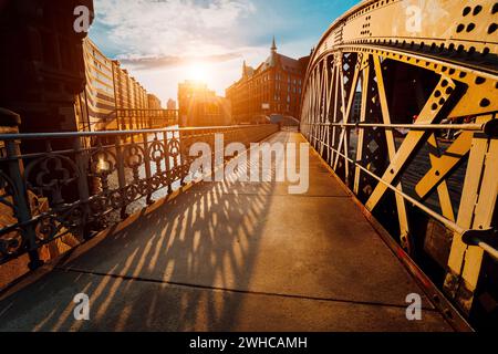 Pont Arch avec rivets dans la Speicherstadt de Hambourg pendant l'heure d'or du coucher du soleil avec lumière du coucher du soleil. Banque D'Images