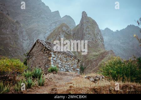 Entrepôt local en ruine niché dans un paysage incroyable avec des rochers de montagne escarpés et des sommets verticaux. Trekkingtrail sur Santo Antao Cap-Vert. Banque D'Images