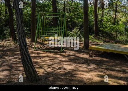 Banc oscillant en métal sous les arbres dans un parc ombragé en bord de route en Corée du Sud Banque D'Images