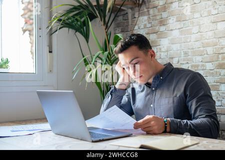 Confus jeune homme frustré lisant lettre, notification de dette, mauvais rapport financier, problème d'argent, problème d'argent, un étudiant énervé qui reçoit de mauvaises nouvelles, un examen ou des résultats de test infructueux Banque D'Images