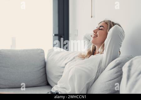 Jeune femme calme se relaxant reposant sur un canapé confortable sieste sur le canapé dans le salon se reposant ayant une sieste tranquille saine, respirant l'air frais, pas de week-end sans stress à la maison, la tranquillité d'esprit Banque D'Images