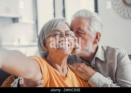 Portrait de tête portrait heureux couple senior prenant selfie, s'amusant avec la caméra de téléphone, femme âgée souriante et mari embrassant, regardant la caméra, posant pour la photo, homme âgé vlogger enregistrant la vidéo Banque D'Images