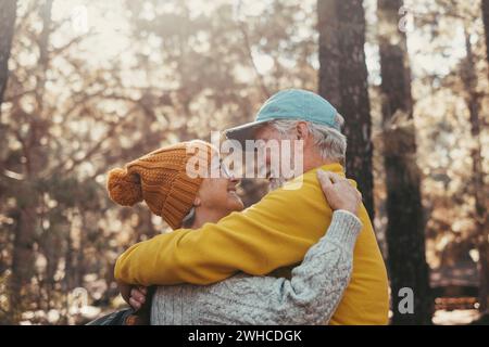 Portrait, gros plan de vieilles personnes souriantes et jouissant de se regarder dans la forêt de montagne. Mignon couple de seniors matures amoureux se sentant heureux et prenant soin. Banque D'Images