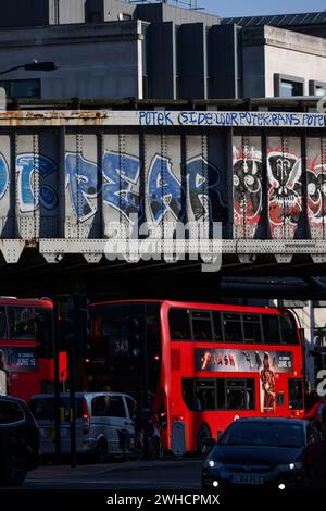 Le soir, le trafic aux heures de pointe passe sous un chemin de fer graffiné près de London Bridge Station. Borough High Street, Londres, Royaume-Uni. 7 juin 2023 Banque D'Images