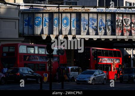 Le soir, le trafic aux heures de pointe passe sous un chemin de fer graffiné près de London Bridge Station. Borough High Street, Londres, Royaume-Uni. 7 juin 2023 Banque D'Images