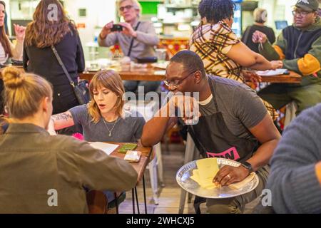 Detroit, Michigan, États-Unis. 8 février 2024. Le gouverneur Garlin Gilchrist, du Michigan, a passé une heure en tant que serveur au restaurant Yum Village pour promouvoir la campagne pour un juste salaire. One Fair Wage fonctionne pour un salaire minimum vital pour tous et l'élimination du salaire inférieur au salaire minimum pour les travailleurs pourvus de pourboires. Crédit : Jim West/Alamy Live News Banque D'Images