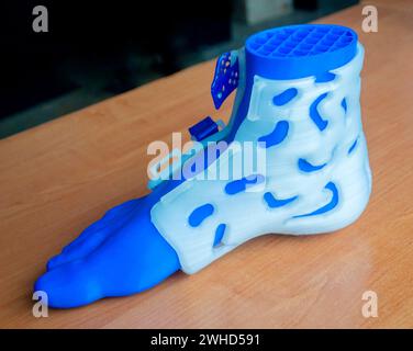 Corset corset à attelle médicinale pour pied et modèle de pied humain imprimé sur imprimante 3D à partir de plastique fondu. Orthèse médicale, fixateur, superposition en plastique pour jambe et jambe humaine créée sur imprimante 3D. Banque D'Images