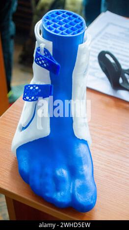 Corset corset à attelle médicinale pour pied et modèle de pied humain imprimé sur imprimante 3D à partir de plastique fondu. Orthèse médicale, fixateur, superposition en plastique pour jambe et jambe humaine créée sur imprimante 3D. Banque D'Images