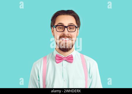 Portrait de hipster nerd masculin drôle dans des vêtements colorés élégants sur fond bleu clair. Banque D'Images