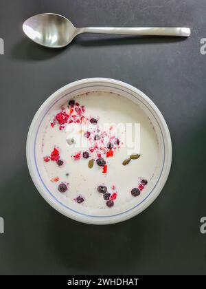 Muesli avec du lait dans un bol pour le petit déjeuner, muesli aux fruits avec des grains et des fruits, cuillère Banque D'Images