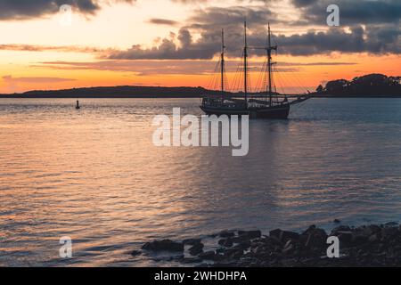 Un trois maîtres est ancré au large de la côte ouest française en Bretagne au coucher du soleil, couleurs chaudes, ambiance de vacances Banque D'Images