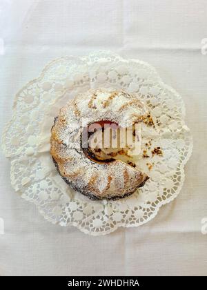 Gâteau de marbre tranché avec du sucre en poudre sur une nappe blanche et une assiette Banque D'Images