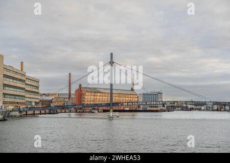 L'ancien bâtiment classé KWO (Kabelwerk Oberspree) et le Kaisersteg Brucke au premier plan par temps nuageux, Treptow - Koepenick, Berlin, Allemagne Banque D'Images