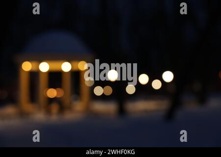 Gazebo et neige dans le parc du soir, vue floue Banque D'Images