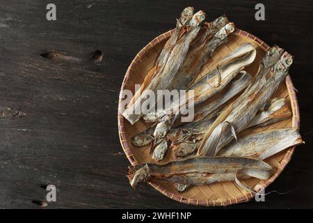 Poisson salé à base d'espadon séché au soleil ou de ceinture de poisson. IKAN ASIN Layur sur plateau en bambou. Vue de dessus Banque D'Images