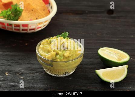 Sauce guacamole sauce avocat avec nachos sur table en bois Banque D'Images