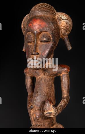 Gros plan d'une figurine Senufo mâle en bois de Côte d'Ivoire. Art africain tribal, mettant en valeur un savoir-faire magistral et un symbolisme spirituel. Banque D'Images