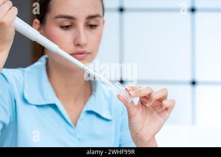 Le scientifique pipette dans une cuvette Banque D'Images