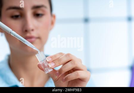 Le scientifique pipette dans une cuvette Banque D'Images