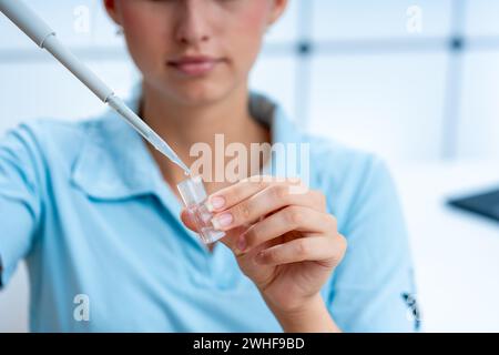 Le scientifique pipette dans une cuvette Banque D'Images
