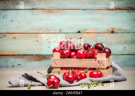 Cerises rouges mûres dans une petite boîte en bois Banque D'Images