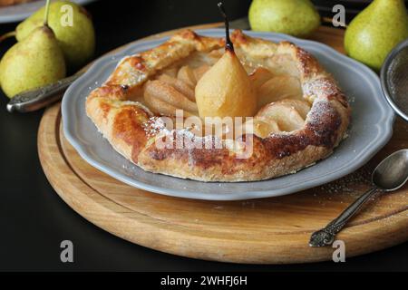 Galette faite maison avec les poires sur fond noir. Cuisine française - galette bretonne. Tarte sucré ouvrir Banque D'Images