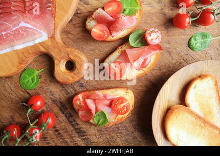 Avec Bruschetta jambon prosciutto, tomates cerise et vert les épinards . Vue d'en haut Banque D'Images