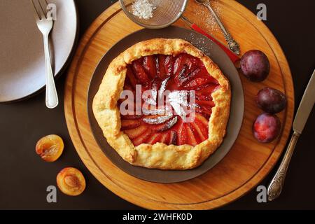 Maison saine de farine de galette fruits prunes avec le sucre en poudre Banque D'Images