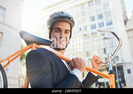 Matin, vélo et ville avec portrait d'homme d'affaires avec navette pour le transport vert et durable. Cycliste, sourire et vélo pour une empreinte carbone Banque D'Images