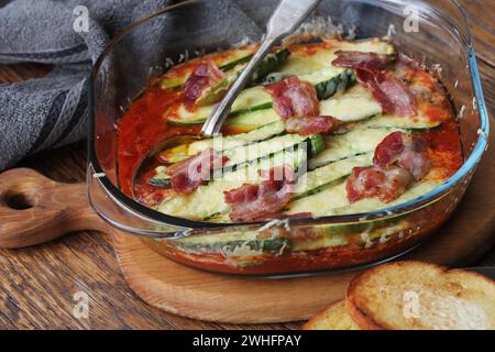 Poêle à frire les tomates, les courgettes, le fromage et les herbes sur planche à découper en bois Banque D'Images
