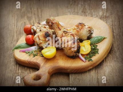 Cuisses de poulet grillées au romarin servi sur une planche à découper le dîner historique Banque D'Images