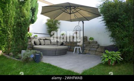 Terrasse de jardin avec groupe lounge et parasol dans un coin jardin Banque D'Images