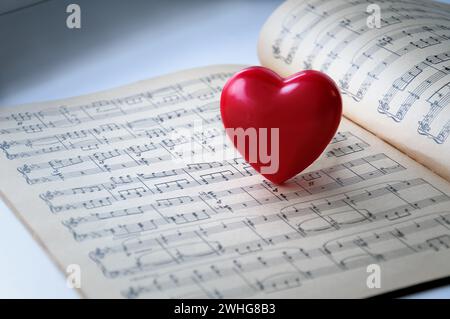 Cœur rouge sur fond de notes. Le cœur rouge est sur les notes. Banque D'Images