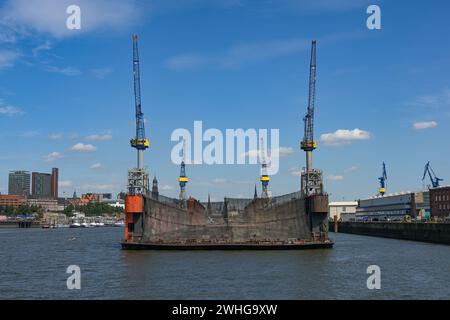 Quai flottant avec quatre grues où les navires sont réparés dans le port de fret industriel de Hambourg, ville en arrière-plan, SK bleu Banque D'Images