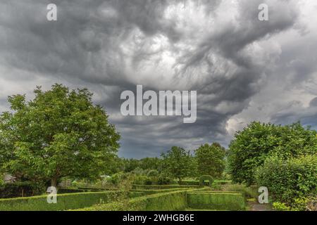 Tempête approchant au-dessus d'un jardin verdoyant un après-midi d'été Banque D'Images